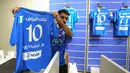 Seorang pegawai toko resmi klub sepak bola Saudi Al-Hilal memamerkan jersey yang baru dicetak bertuliskan nama dan nomor punggung penyerang Brasil Neymar Jr. di Riyadh pada 15 Agustus 2023.  (Photo by Fayez Nureldine / AFP)