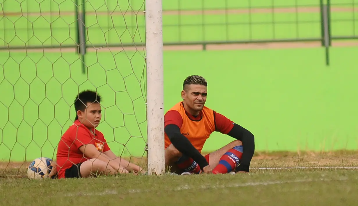 Cristian Gonzales ditemani anaknya Fernando Gonzales saat berlatih bersama Arema Cronus di Stadion Gajayana, Malang, Jumat (30/10/2015). (Bola.com/Kevin Setiawan)