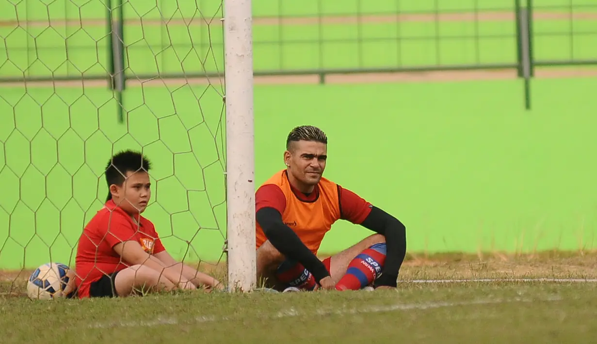 Cristian Gonzales ditemani anaknya Fernando Gonzales saat berlatih bersama Arema Cronus di Stadion Gajayana, Malang, Jumat (30/10/2015). (Bola.com/Kevin Setiawan)