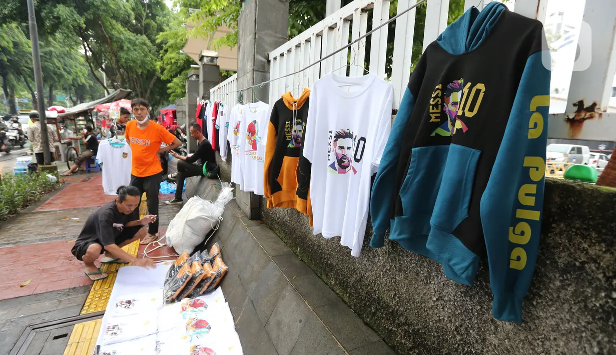 Pertandingan Timnas Indonesia Vs Argentina membuat pedagang ketiban rezeki berlimpah. Mereka kompak berjualan aneka macam merchandise di antaranya baju, Jersey, syal, topi, dll. (Bola.com/Muhammad Iqbal Ichsan)