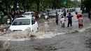 Sejumlah kendaraan nekat menerobos banjir di depan Mall Gandaria City, Jakarta, Sabtu (27/8). Hujan deras di wilayah Jabodetabek membuat jalan tersebut banjir setinggi 30-50 cm. (Liputan6.com/Helmi Afandi)