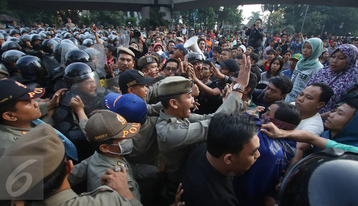 Warga dan Satpol PP terlibat saling dorong saat eksekusi penggusuran di kawasan Rawajati, Pancoran, Jakarta, Kamis (1/9). Bentrokan warga-Satpol PP mewarnai aksi penolakan penggusuran bangunan di atas jalur hijau tersebut. (Liputan6.com/Immanuel Antonius)