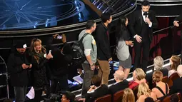Host Piala Oscar 2017, Jimmy Kimmel mengajak masuk para turis ke perhelatan Academy Awards ke-89, di California, Minggu (26/2). Para turis ini tak pernah menyangka bahwa mereka seketika berada di dalam Dolby Theatre. (Kevin Winter/Getty Images/AFP)