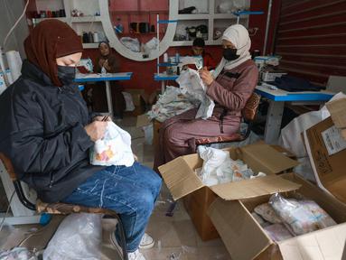 Wanita Palestina menjahit popok di sebuah pabrik di Rafah, selatan Jalur Gaza, pada 18 Februari 2024. (MOHAMMED ABED/AFP)