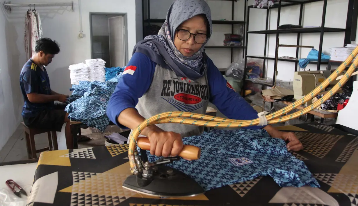 Pekerja menyetrika baju seragam sekolah di rumah ronveksi Fia Busana Sawangan Depok, Jawa Barat, Rabu (08/07/2026). (KLY/ Arie Basuki)