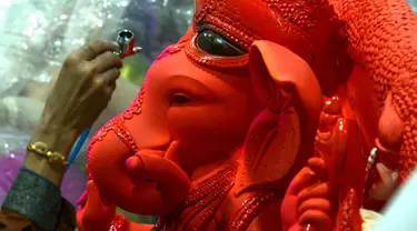 Seorang perajin mengerjakan pembuatan patung Dewa Ganesha di sebuah bengkel di Mumbai, India, 24 Agustus 2021. Pembuatan patung dewa Hindu berkepala gajah tersebut dilakukan jelang Festival Ganesh Chaturthi. (SUJIT JAISWAL/AFP)