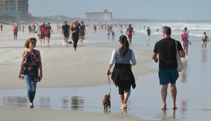Warga berjalan di pantai selama pandemi Covid-19 di Jacksonville Beach, Florida (17/4/2020). Gubernur Ron DeSantis memberikan lampu hijau beberapa pantai dan taman untuk dibuka kembali jika dapat dilakukan dengan aman setelah ditutup karena Covid-19.  (Will Dickey/The Florida Times-Union via AP)