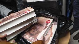 Buku baru Pangeran Harry berjudul "Spare" dipegang oleh anggota staf toko buku saat pembukaan tengah malam di London, Selasa (10/1/2023). Memoar baru Harry yang memamerkan jiwa, "Spare," telah menghasilkan berita utama yang membara bahkan sebelum dirilis. (AP/Alberto Pezzali)