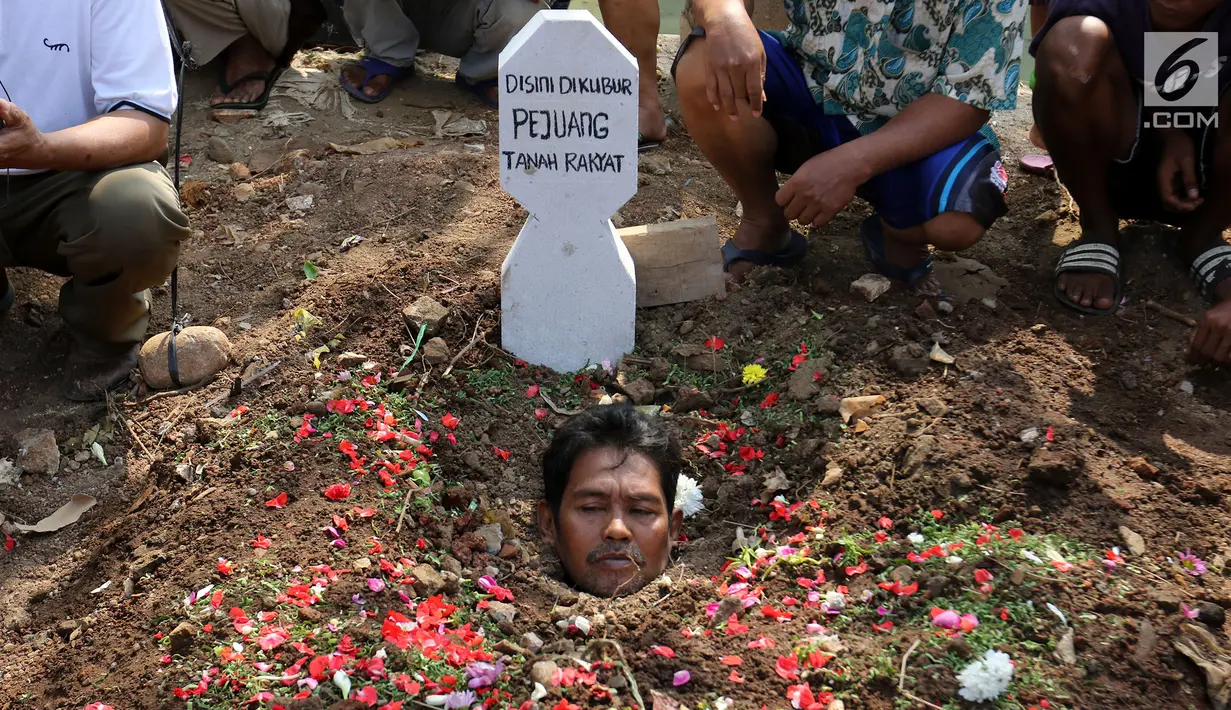 Warga yang tergabung dalam Aliansi Tanah Untuk Rakyat melakukan aksi kubur diri di Taman Kayu Mas, Pulogadung, Jakarta Timur, Jumat (23/8/2019). Mereka menuntu sengketa tanah antara warga dengan badan pertanahan DKI Jakarta diselesaikan. (Liputan6.com/Herman Zakharia)