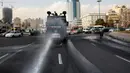 Kendaraan Water Canon kepolisian menyempotkan desinfektan untuk mensterilkan jalan-jalan di Teheran, Iran pada 1 Maret 2020. Sejauh ini, Iran mencatat ada 1.501 kasus virus Corona dengan 66 korban meninggal. (AP Photo/Vahid Salemi)