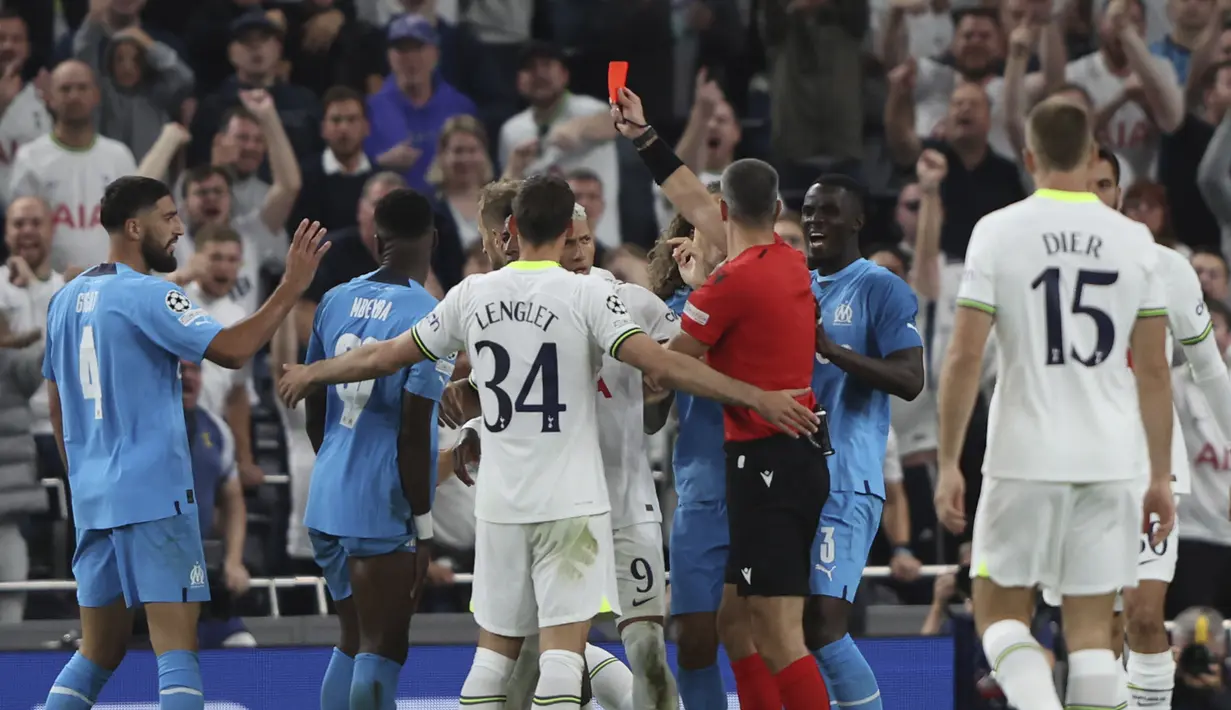 Wasit Slavko Vincic menunjukkan kartu merah kepada pemain Marseille, Chancel Mbemba Marseille saat pertandingan antara Tottenham Hotspur dan Marseille pada Grup D Liga Champions di stadion Tottenham Hotspur, di London, Inggris, Kamis (8/9/2022). Dengan kemenangan ini, Tottenham berada di peringkat kedua klasemen dengan 3 poin. (AP Photo/Ian Walton)