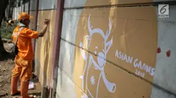 Petugas Penanganan Prasarana dan Sarana Umum (PPSU) membuat mural bertema Asian Games 2018 di kawasan Cawang, Jakarta, Selasa (17/7). Mural tersebut untuk menyambut dan memeriahkan Asian Games 2018 pada Agustus mendatang. (Liputan6.com/Faizal Fanani)