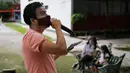 Percibald Garcia menggunakan mikrofon untuk membacakan cerita anak-anak di tengah-tengah kompleks perumahan Tlatelolco di Mexico City pada 18 Juli 2020. Lockdown akibat pandemi corona membuat arsitek muda berusia 27 tahun itu memutuskan untuk berbagi cerita menghibur anak-anak. (AP/Marco Ugarte)