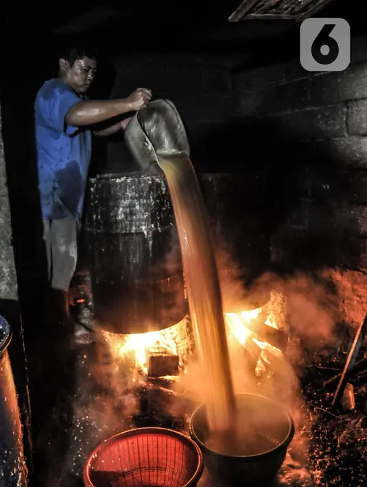 Pekerja menuang kedelai rebus saat proses pembuatan tempe di kawasan Sunter, Jakarta, Senin (4/1/2021). Perajin tempe setempat berupaya mengurangi kerugian akibat melonjaknya harga kedelai impor dengan memperkecil ukuran tempe dan menaikan harga jual. (merdeka.com/Iqbal S. Nugroho)