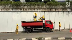 Pasukan Kuning mengecat dinding Underpass Kebayoran Baru, Jakarta Selatan, Kamis (1/2). Pengecatan dilakukan sebagai bentuk perawatan. (Liputan6.com/Immanuel Antonius)