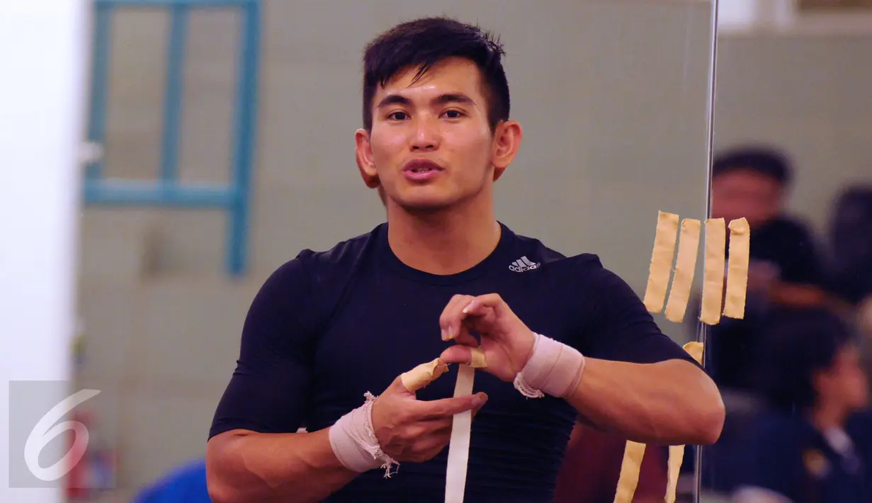 Lifter M Hasbi memasang pengaman tangan jelang seleksi nasional untuk olimpiade Rio de Janeiro 2016 di PB PABBSI, Jakarta, Sabtu (4/6/2016). 17 lifter mengikuti seleksi nasional untuk berlaga di ajang olimpiade 2016. (Liputan6.com/Helmi Fithriansyah)