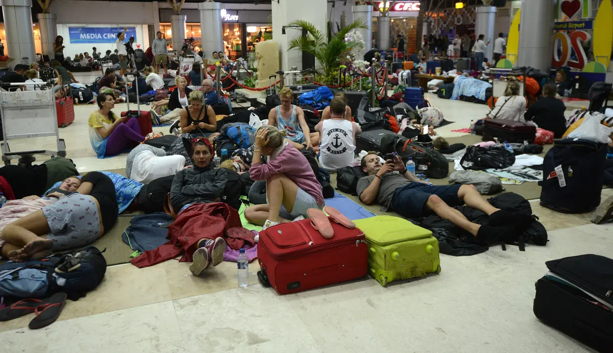 Wisatawan asing tidur di lantai saat menunggu jadwal keberangkatan pesawat di Bandara Internasional Praya Lombok, NTB, Senin (6/8). Imbas gempa 7 SR, para wisatawan terlantar di bandara karena jam pemberangkatan pesawat yang tertunda (AFP/SONNY TUMBELAKA)