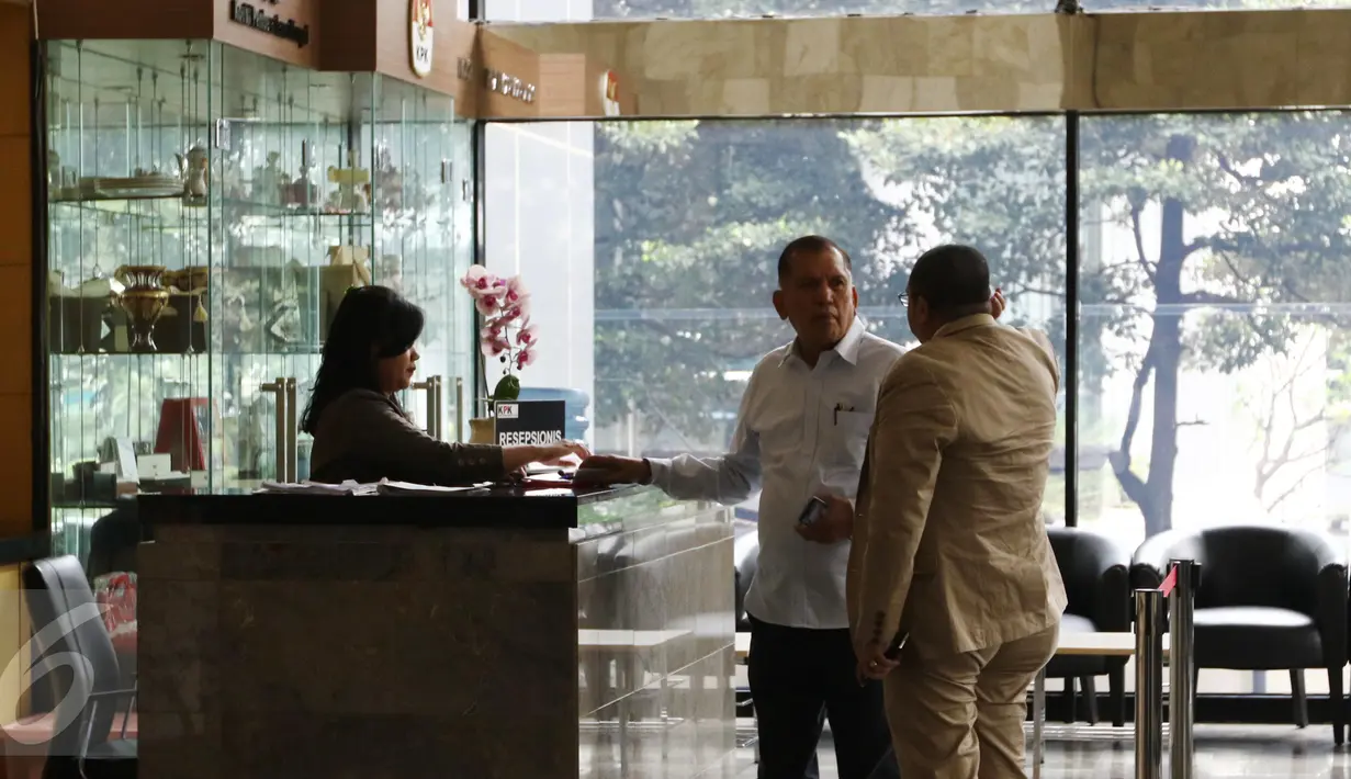 Chairuman Harahap ketika memberikan kartu identitasnya di meja resepsionis Gedung KPK, Jakarta, sebelum menjalani pemeriksaan terkait kasus dugaan korupsi pengadaan KTP Elektronik tahun 2011-2012, Selasa (11/10). (Liputan6.com/Helmi Affandi)