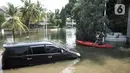 Warga beraktivitas menggunakan perahu melintasi mobil terendam banjir rob di Kompleks Perumahan Pantai Mutiara, Pluit, Jakarta, Minggu (7/6/2020). (merdeka.com/Iqbal S. Nugroho)