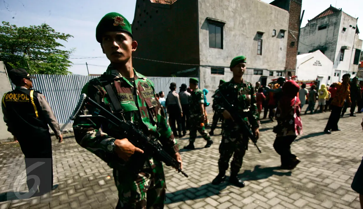 Prajurit TNI berjaga saat pembagian sembako oleh Presiden Joko Widodo atau Jokowi di halaman Gedung Graha Saba, Solo, Jawa Tengah, Jumat (8/7). Keluarga Jokowi membagikan 2.200 paket sembako kepada warga Solo. (Liputan6.com/Boy Harjanto)
