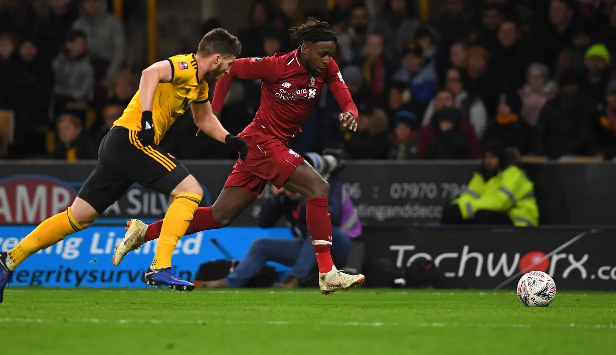 Bek Wolverhampton Wanderers, Matt Doherty dan striker Liverpool, Divock Origi mengejar bola pada laga putaran ketiga Piala FA di Molineux Stadium, Senin (7/1). Liverpool tersingkir dari Piala FA setelah takluk 1-2 dari Wolverhampton (Paul ELLIS/AFP)