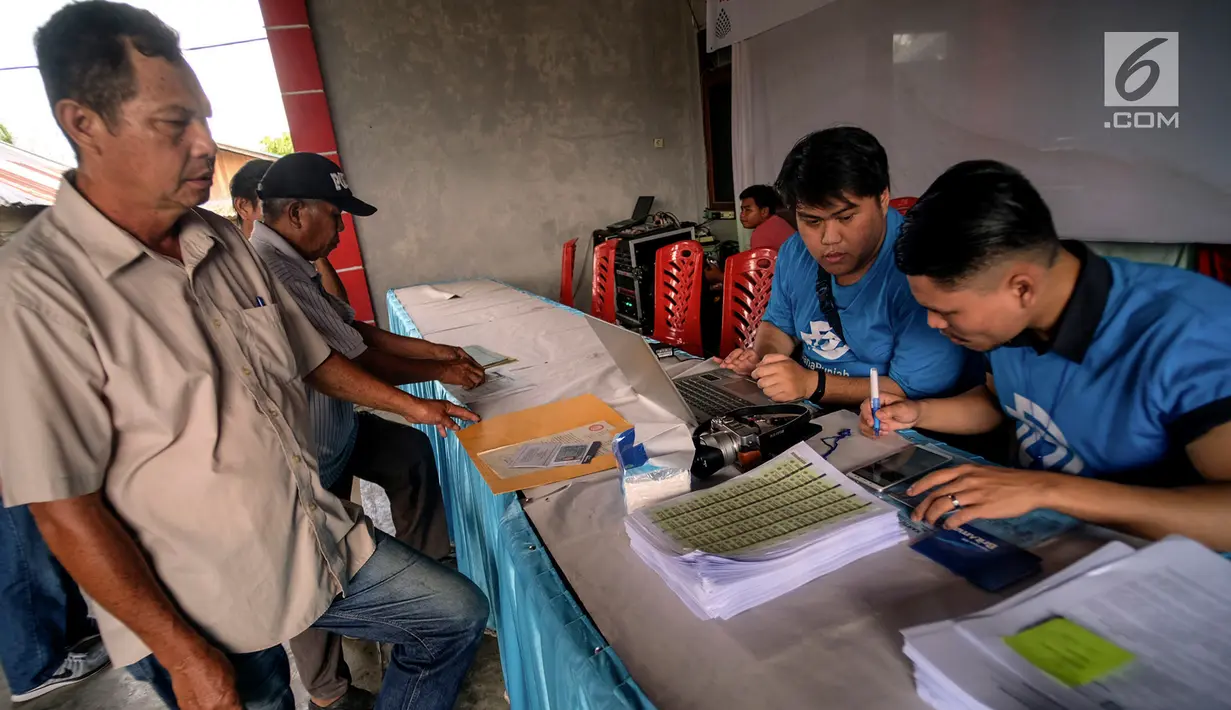 Petugas DanaRupiah, platform Fintech Peer to Peer (P2P) Lending menyalurkan kredit produktif kepada petani jagung di Kotamobagu, Bolaang Mongondow, Sulawesi Utara, Kamis (4/7/2019). Penyaluran kredit dengan total nilai Rp 1,5 miliar digunakan untuk pembelian bibit dan pupuk. (Liputan6.com/HO/Ading)