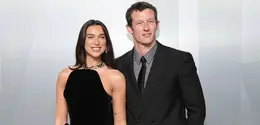 Dua Lipa tampil memukau dalam balutan gaun Schiaparelli bernuansa emas metalik dengan detail fur dramatis, menciptakan siluet sensual sekaligus bold. Ia tampak serasi dengan sang tunangan, Callum Turner, yang memilih setelan klasik bernuansa krem dengan bow tie hitam. Perpaduan mereka memancarkan aura old Hollywood glamour yang modern.