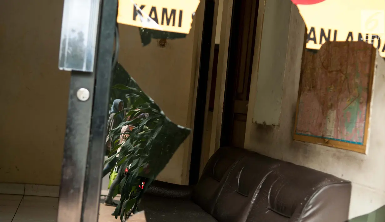 Warga melintas didepan Pos Polisi Subsektor Monas Barat, Gambir, Jakarta, Jumat (26/5). Pengrusakan terjadi pada kamis malam tersebut diduga oknum yang mengaku sebagai aparat. (Liputan6.com/Gempur M Surya)