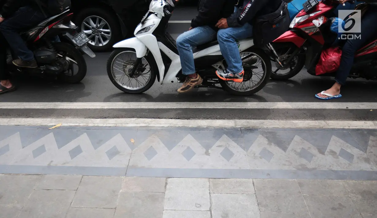 Sepeda motor dan kendaraan lainnya menunggu lampu merah di persimpangan kawasan MH Thamrin, Jakarta, Jumat (20/9). BPTJ Kementerian Perhubungan berencana membatasi volume sepeda motor untuk menekan angka kecelakaan di Ibu Kota.(Liputan6.com/Faizal Fanani)