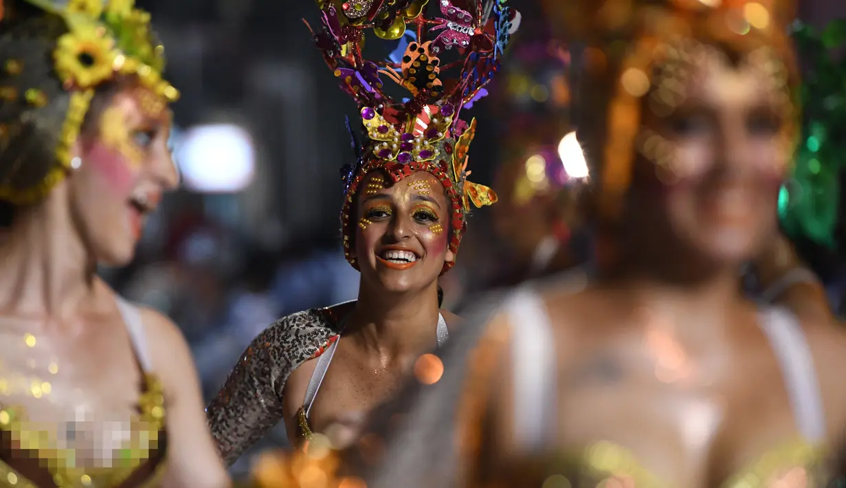 Anggota karnaval Uruguay, Comparsa, melakukan pertunjukkan tari selama parade karnaval Llamadas di Montevideo, Kamis (7/2). Para penari dengan menggunakan berbagai kostum menarik meriahkan parade tersebut di jalanan Montevideo. (PABLO PORCIUNCULA/AFP)