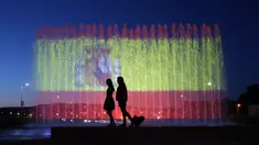 Warga berjalan di depan air mancur yang diterangi warna bendera nasional Spanyol sebagai penghormatan kepada korban teror Barcelona di Zagreb, Kroasia (18/8). Lebih dari 100 orang luka-luka dan 14 orang tewas akibat kejadian tersebut. (AFP Photo/Str)