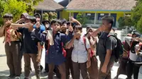 Para siswa SDN I Wegil terpaksa menutup hidungnya akibat dikepung hujan debu akibat aktivitas tambang batu kapur Pegunungan Kendeng. (Liputan6.com/Arief Pramono)