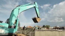 Pekerja dibantu alat berat melakukan pengecoran site pile normalisasi kali Ciliwung, Jakarta, Jumat (13/1). Meski warga Bukit Duri memenangkan gugatan di PTUN Jaksel, proyek normalisasi sungai Ciliwung tetap berlanjut. (Liputan6.com/Yoppy Renato)