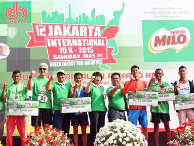 Wagub DKI Djarot Saiful (keempat kiri) dan juara Jakarta International 10K 2015 kategori elit nasional putra, Jauhari Johan (kedua kanan) berfoto bersama seusai penyerahan hadiah di Silang Monas,  Jakarta, Minggu (31/5). (Liputan6.com/Helmi Afandi)