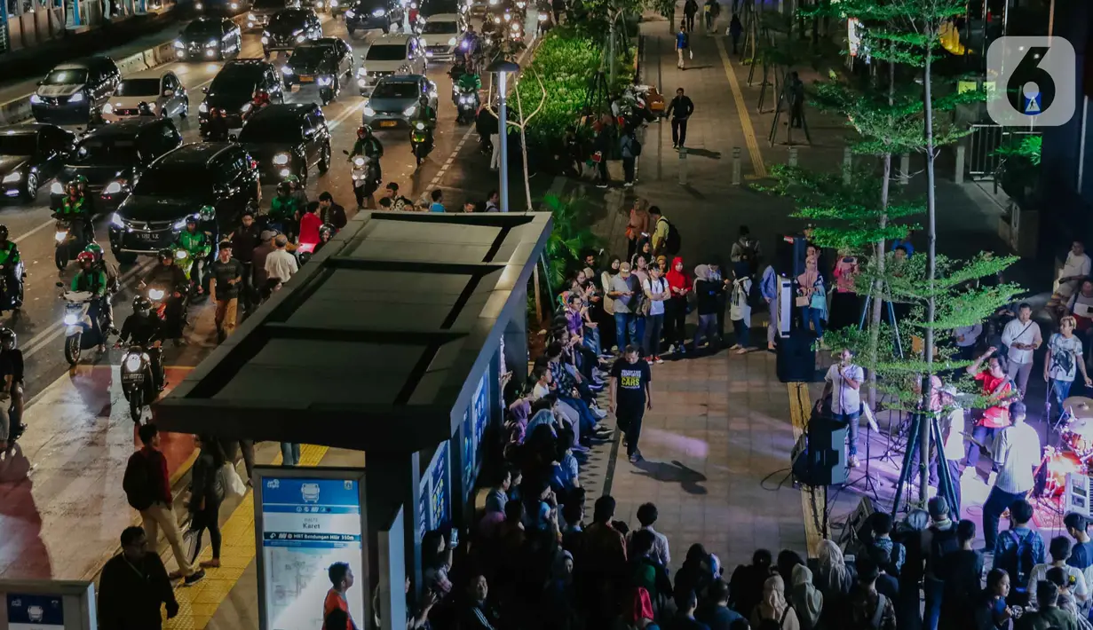 Pejalan kaki menikmati acara bertajuk Musik Tepi Barat dan Timur di jalur pedestrian kawasan Sudirman, Jakarta, Jumat (22/11/2019). Kegiatan rutin itu diadakan Dinas Pariwisata dan Kebudayaan Provinsi DKI pada Selasa dan Jumat mulai pukul 16.30 - 19.30 WIB. (Liputan6.com/Faizal Fanani)