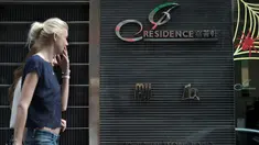 Warga berjalan di depan apartemen J Residence, lokasi pembunuhan 2 WNI di Hong kong, Minggu (2/11/2014). (AFP PHOTO/Nicolas ASFOURI)