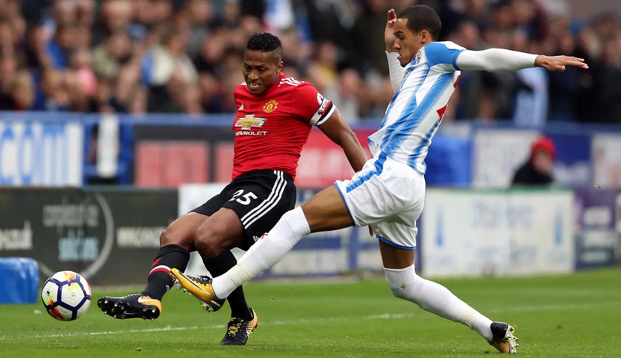 Pemain Manchester United, Valencia berebut bola dengan pemain Huddersfield, Tom Ince saat pertandingan Liga Inggris di stadion John Smith di Huddersfield (21/10). Huddersfield menang 2-1 atas Manchester United. (Nigel French / PA via AP)