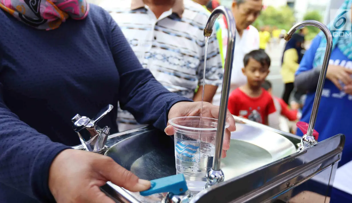 Warga mengambil air minum gratis saat run for water di CFD, Jakarta, Minggu (25/3). Run For Water kolaborasi PAM Jaya, Palyja, dan Aetra mengkampanyekan Hari Air Dunia 2018 mengajak masyarakat ayo peduli air Jakarta. (Liputan6.com/Angga Yuniar)