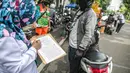 Petugas mendata pengendara saat uji emisi gas buang kendaraan bermotor di Jakarta, Rabu (6/1/2021). Pengecekan yang diselenggarakan Dinas Perhubungan dan Kepolisian tersebut bertujuan untuk mengurangi polusi udara dari emisi gas buang kotor. (Liputan6.com/Faizal Fanani)