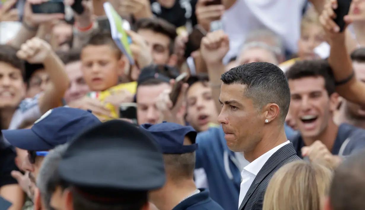 Cristiano Ronaldo saat menyapa suporter Juventus saat tiba di pusat layanan kesehatan Juventus (J-Medical), Turin, Italia, (16/7). Ronaldo akan mengenakan nomor punggung 7, seperti yang dikenakannya di Real Madrid. (AP Photo/Luca Bruno)