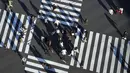 Orang-orang yang memakai masker untuk membantu mengekang penyebaran COVID-19 menyeberangi jalan di Tokyo, Jepang, 29 Desember 2021. Kepala Rumah Sakit Pusat Sumida Dr Kuniaki Kojima memperkirakan saat ini gelombang keenam COVID-19 di Jepang sudah dimulai. (AP Photo/Eugene Hoshiko)