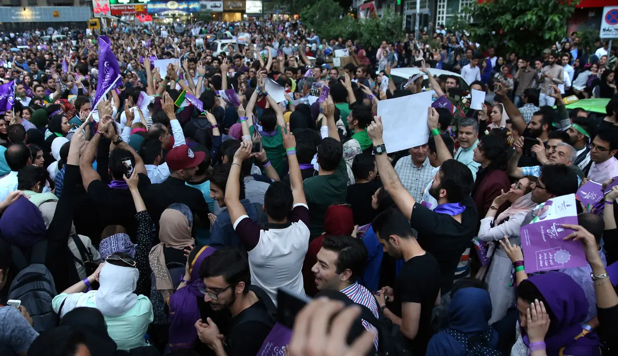 Ribuan pendukung Presiden Iran Hassan Rouhani turun ke jalan untuk merayakan kemenangannya dalam pemilihan presiden Iran di Teheran, Iran (20/5). Pemilihan presiden Iran telah digelar pada Jumat (19/5) waktu setempat. (AP Photo/Ebrahim Noroozi)