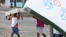 Penjarah membawa kasur yang baru saja mereka jarah dari sebuah toko di Managua, Nikaragua, Minggu (22/4). Pemerintah Nikaragua meningkatkan pajak dan memotong tunjangan pensiun dalam sistem jaminan sosial. (AP Photo/Alfredo Zuniga)