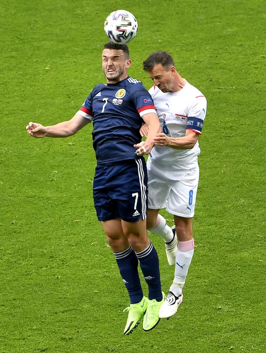 Gelandang Skotlandia, John McGinn berebut bola udara dengan pemain Republik Ceko, Vladimir Darida pada pertandingan grup D Euro 2020 di stadion Hampden Park, Glasgow, Senin (14/6/2021). Ceko menang atas Skotlandia dengan skor 2-0. (AP Photo/Andy Buchanan, Pool)