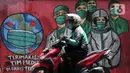 Pengedara motor melintas di depan mural tentang pandemi virus COVID-19 di Jalan Raya Jakarta-Bogor, Depok, Jawa Barat, Selasa (7/4/2020). Mural tersebut sebagai bentuk dukungan kepada tenaga medis yang menjadi garda terdepan menghadapi COVID-19 di Indonesia. (Liputan6.com/Helmi Fithriansyah)