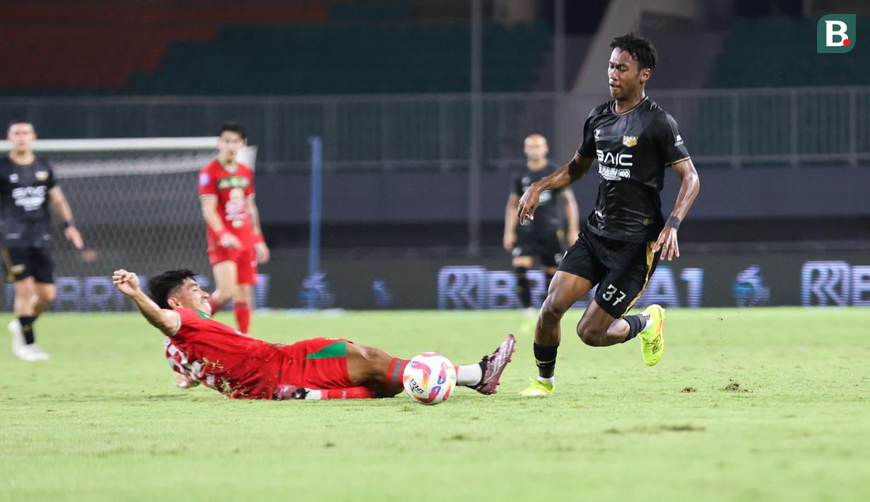 Pemain Dewa United, Alta Balah (kanan) berhasil melewati hadangan pemain Persebaya Surabaya dalam pertandingan Dewa United melawan Persebaya Surabaya pada pekan ke-24 BRI Liga 1 di Stadion Pakansari, Kabupaten Bogor, Jumat (21/2/2025) malam WIB. (Bola.com/Abdul Aziz)