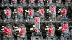 Deretan patung Jizo berdiri di Kuil Buddha Jizoji, Oganomachi, Prefektur Saitama, Jepang, Senin (13/8). Kuil Jizoji mengabadikan sekitar 15.000 patung batu jizo. (Behrouz Mehri/AFP)