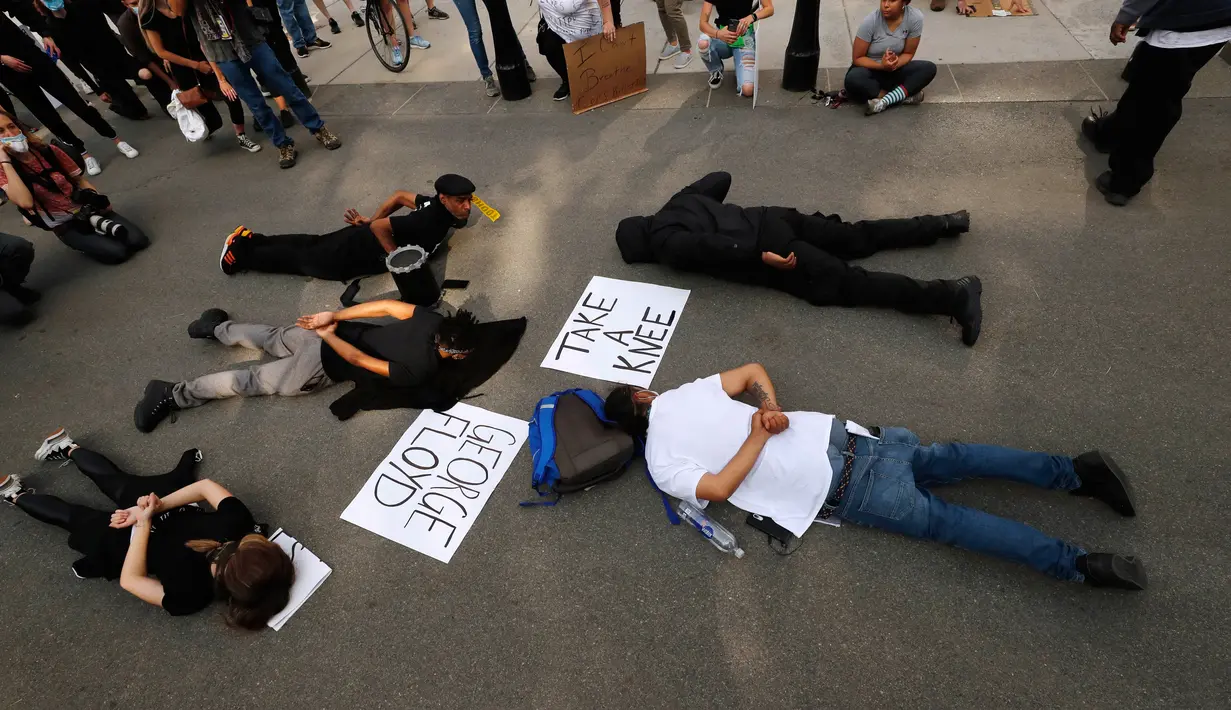 Demonstran berbaring telungkup menggambarkan George Floyd selama aksi protes terhadap kebrutalan polisi di Boston Common, Rabu (3/6/2020). Aksi tersebut menyimbolkan momen terakhir Floyd saat lehernya ditindih lutut oleh petugas kepolisian Minneapolis pada 25 Mei lalu. (AP/Charles Krupa)