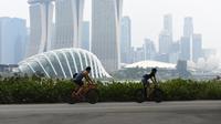 Warga beraktivitas saat kabut asap menyelimuti kota Singapura (15/9/2019). Akibat kabut asap yang terjadi di kota tersebut membuat Grand Prix Formula 1 di Singapura pekan depan, 20-22 September 2019, terancam batal.  (AFP Photo/Roslan Rahman)