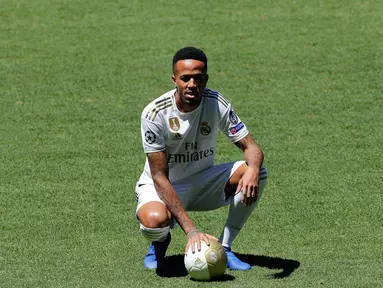 Bek Brasil Eder Militao (kiri) bersama Presiden Real Madrid Florentino Perez berpose dengan jersey klub selama pengenal dirinya di stadion Santiago Bernabeu di Madrid, Spanyol (10/7/2019). Eder Militao diboyong Madrid dari FC Porto dengan transfer 50 juta euro. (AP Photo/Manu Fernandez)